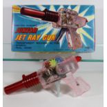 A 1960's Japanese K.O. Junior Jet Ray Gun. In clear and red plastic, with a friction powered