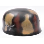 A re-enactment copy of a WWII German paratrooper’s steel helmet, with smooth camouflage painted