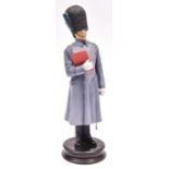 A fine Michael Sutty painted porcelain figure of an officer of the Irish Guards, in great coat and
