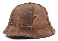 A German M16 style steel helmet, with glued on WWII style hessian covering, iron wire binding, and