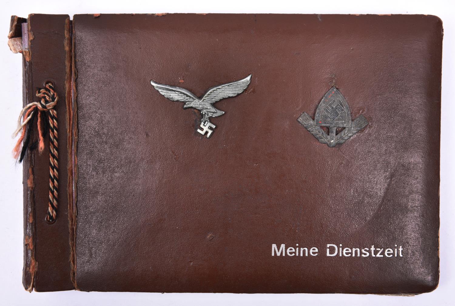 A Third Reich photograph album, the cover mounted with Luftwaffe metal cap eagle and RAD metal cap