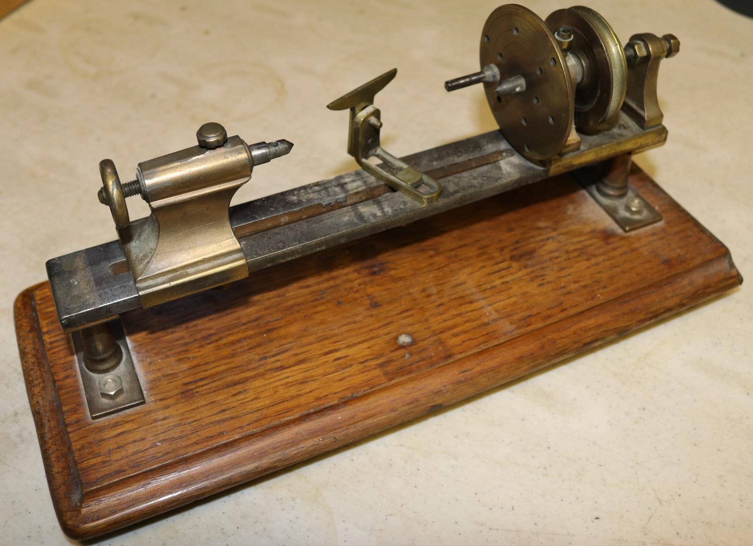 A small brass model of a basic wood turning lathe. Mounted on a hardwood plinth. Intended to be a - Image 2 of 3