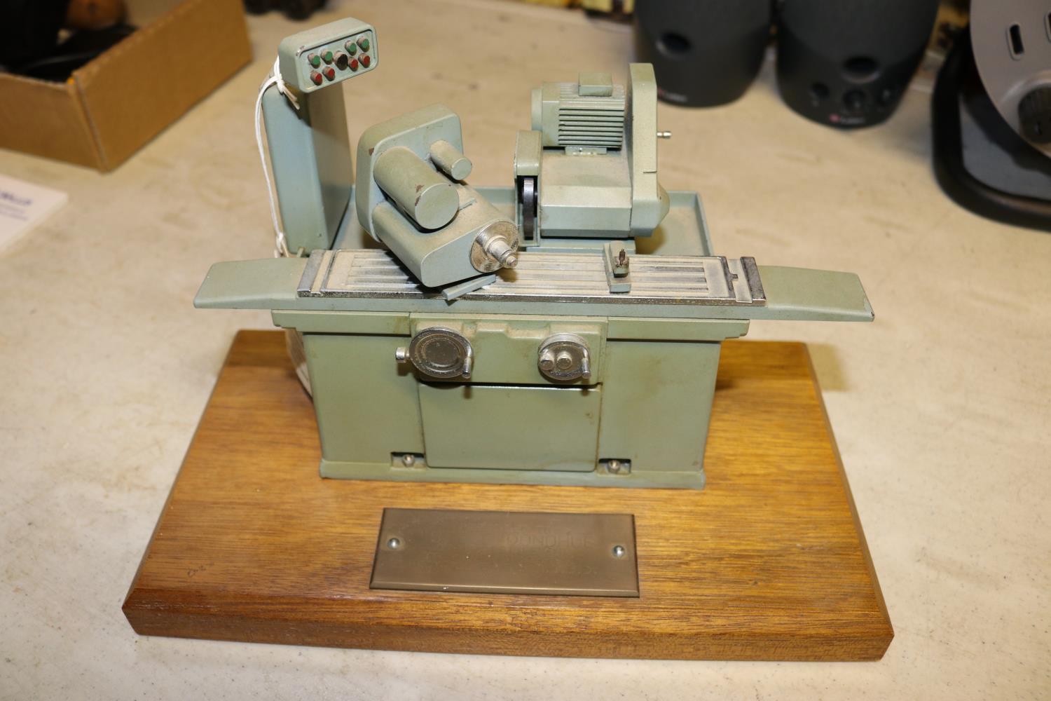 A small metal model of an industrial grinding machine. A well detailed model presented as a