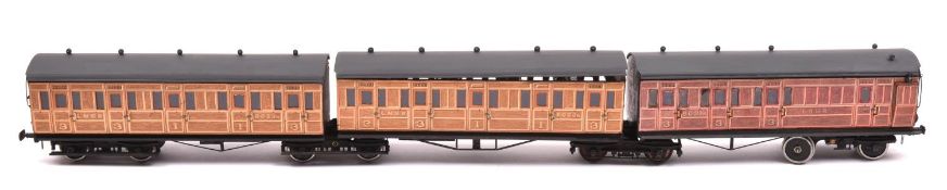 An O gauge possibly Leeds Model Co. LNER 3-car articulated coach set. Teak coaches mounted on 4