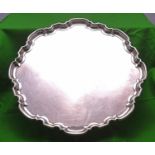 A substantial silver tray on four scrolled feet with decorative raised edge. Hallmarked for