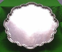 A substantial silver tray on four scrolled feet with decorative raised edge. Hallmarked for