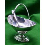 A silver sugar bowl and pierced spoon. A plain oval bowl with hinged handle. Hallmarked London 1904,