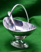 A silver sugar bowl and pierced spoon. A plain oval bowl with hinged handle. Hallmarked London 1904,