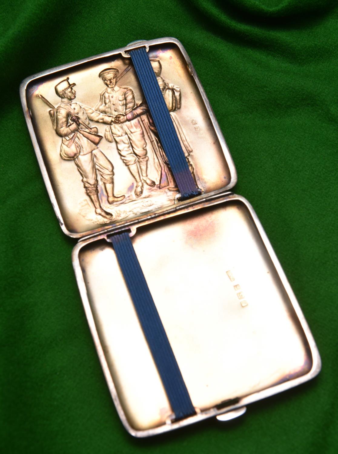 A silver cigarette case with relief decoration of three early 20thC soldiers to lid and gilt wash - Image 2 of 2