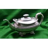 A Georgian rounded rectangular silver teapot with gadrooning decoration to the body, leaf-embossed