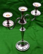 A silver candelabra with two arms and 3 removable sconces. Circular base, octagonal faceted base,