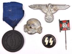 A Third Reich 4 Year Service in the SS medal, SS cap eagle, skull, circular lapel badge and