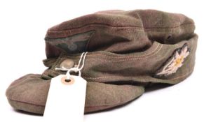 A Third Reich field grey soft ski cap, with BeVo woven one piece eagle and cockade on green patch,