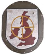 An oval aluminium panel, with border of rivet holes, and with painted shield depicting the British