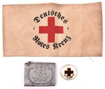 A Third Reich Red Cross man’s belt buckle, and an armband printed with “DEUTSCHES ROTES KREUZ”, also