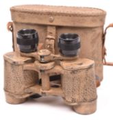 A Third Reich binocular, with eagle stamp and maker’s code “cog”, with sand coloured camouflage