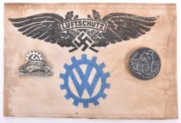 A Third Reich VW factory Luftschutz bund, printed armband; a Volkswagen 1938 pin badge and one other