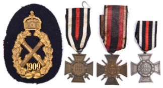 An Imperial German artillery arm badge, gilt crossed cannon within wreath, 3 WWI German crosses.