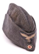 A Third Reich Luftwaffe OR’s grey sidecap, eagle badge and roundel. GC £90-100