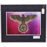 A large black stencilled Third Reich eagle, span 14", on a shaped patch of coarse hessian, mounted