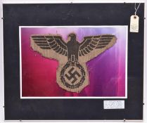 A large black stencilled Third Reich eagle, span 14", on a shaped patch of coarse hessian, mounted