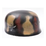 A re-enactment copy of a WWII German paratrooper’s steel helmet, with smooth camouflage painted