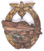 A Third Reich E Boat war badge, bronzed E boat, brass coloured wreath, marked on reverse “FEC E