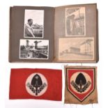 A Third Reich photograph album, the front mounted with an RAD metal cap badge, containing 87