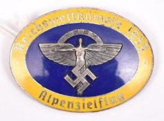 A Third Reich NSKK pin back enamelled badge, with blue centre and outer yellow band inscribed “