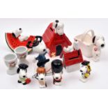 11 Ceramic Peanuts Snoopy Figures. Various types including - Snoopy laying on a slice of water