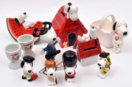 11 Ceramic Peanuts Snoopy Figures. Various types including - Snoopy laying on a slice of water