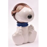 A large ceramic Snoopy character money box sitting in brown flying helmet with blue scarf and