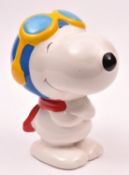 A large ceramic Snoopy character money box standing with red scarf in blue flying helmet and with