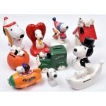 11 Ceramic Snoopy figures. Snoopy with Woodstock on sledge musical box. Unpainted Snoopy lying on