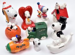 11 Ceramic Snoopy figures. Snoopy with Woodstock on sledge musical box. Unpainted Snoopy lying on