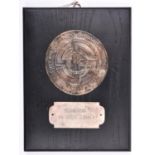 A Third Reich SS plaque, a silvered disc 80mm diam, embossed with inscriptions, SS runes and