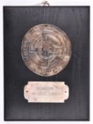 A Third Reich SS plaque, a silvered disc 80mm diam, embossed with inscriptions, SS runes and