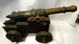 An old replica of a 17th century 1” bore ship’s cannon on its timber carriage, bronzed barrel 31”