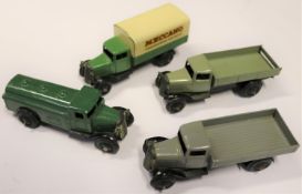4 Dinky Toys 25 Series Trucks. A Wagon (25a). In grey with black chassis. A Covered Wagon (25b).