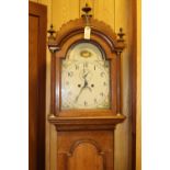 An oak cased longcase clock. Early 19th Century clock striking on a bell with an arched painted