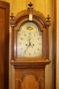 An oak cased longcase clock. Early 19th Century clock striking on a bell with an arched painted