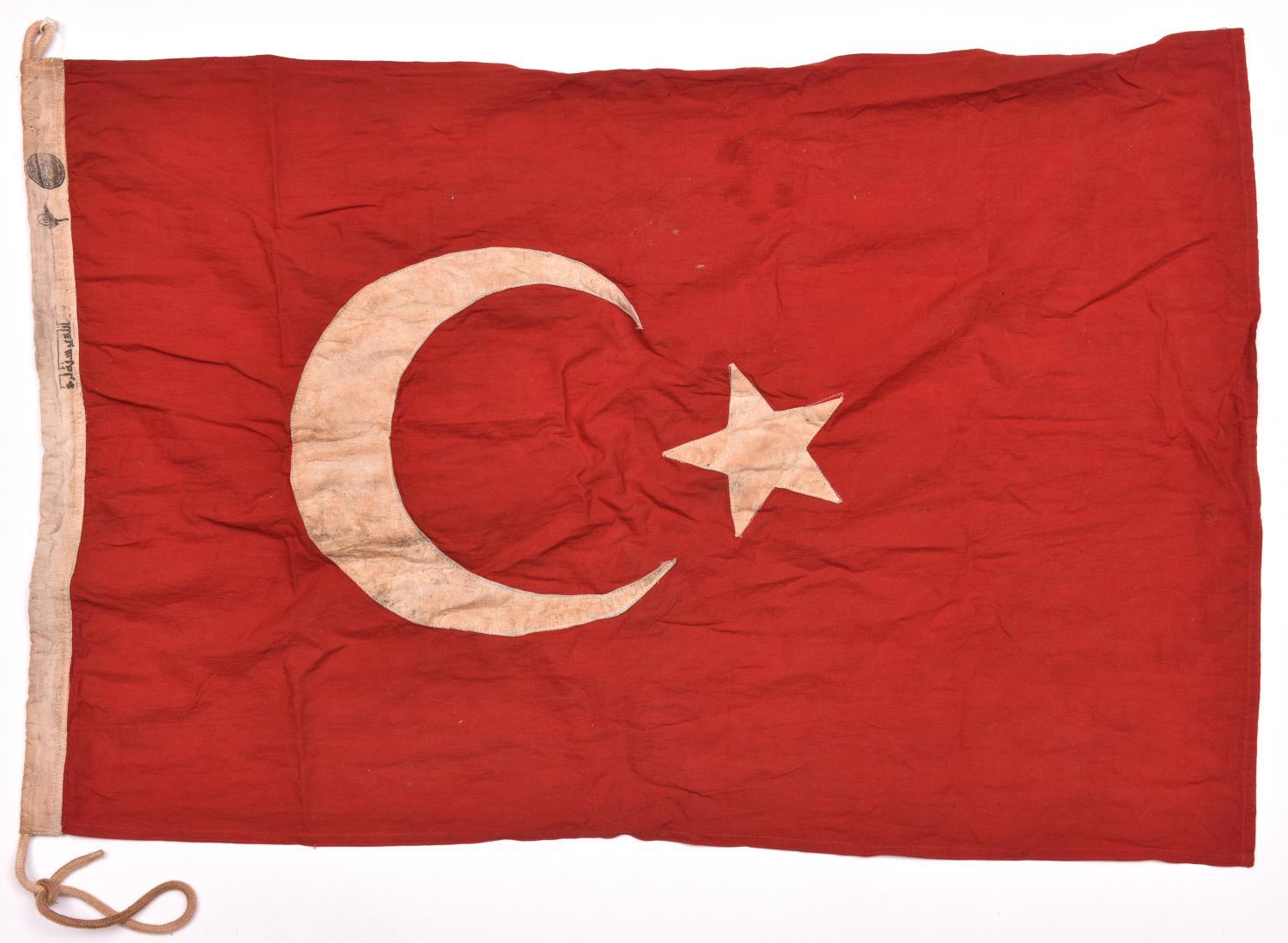 A WWI Turkish flag, 36” x 24”, red cloth with applied white star and crescent, Turkish stamping on