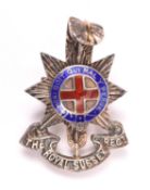 An officer’s cap badge of the Royal Sussex Regiment, of unmarked silver and enamel, with two