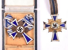 A Third Reich Mother’s Cross, in enamelled bronze, in case of issue; also another in enamelled gilt.