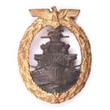 A Third Reich High Seas Fleet badge: gilt eagle and wreath, grey battleship, “SA” in triangle