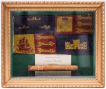 A gilt framed display of a Winston Churchill cigar and a car pennant from Churchill’s car of the