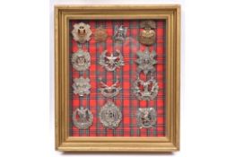 An attractively mounted framed display of 13 Scottish badges, on tartan backing: Ryl Scots, Ryl.