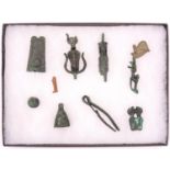 A glazed display case containing 10 small artifacts found at Karnak in 1900 by M. Le Grain, 26