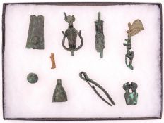 A glazed display case containing 10 small artifacts found at Karnak in 1900 by M. Le Grain, 26