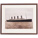 A framed sepia black and white photograph of Titanic. Mounted within a wood cream carded frame